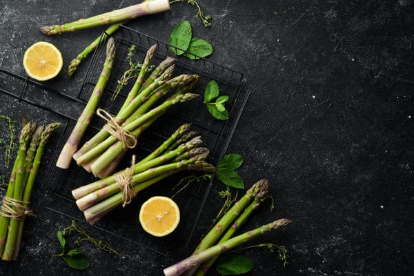 asperges sur fond noir avec citron