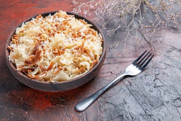 pâte cuite tranchée avec du riz sur une surface sombre plat de pâte repas