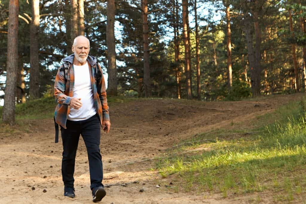 homme âgé marche dans la forêt